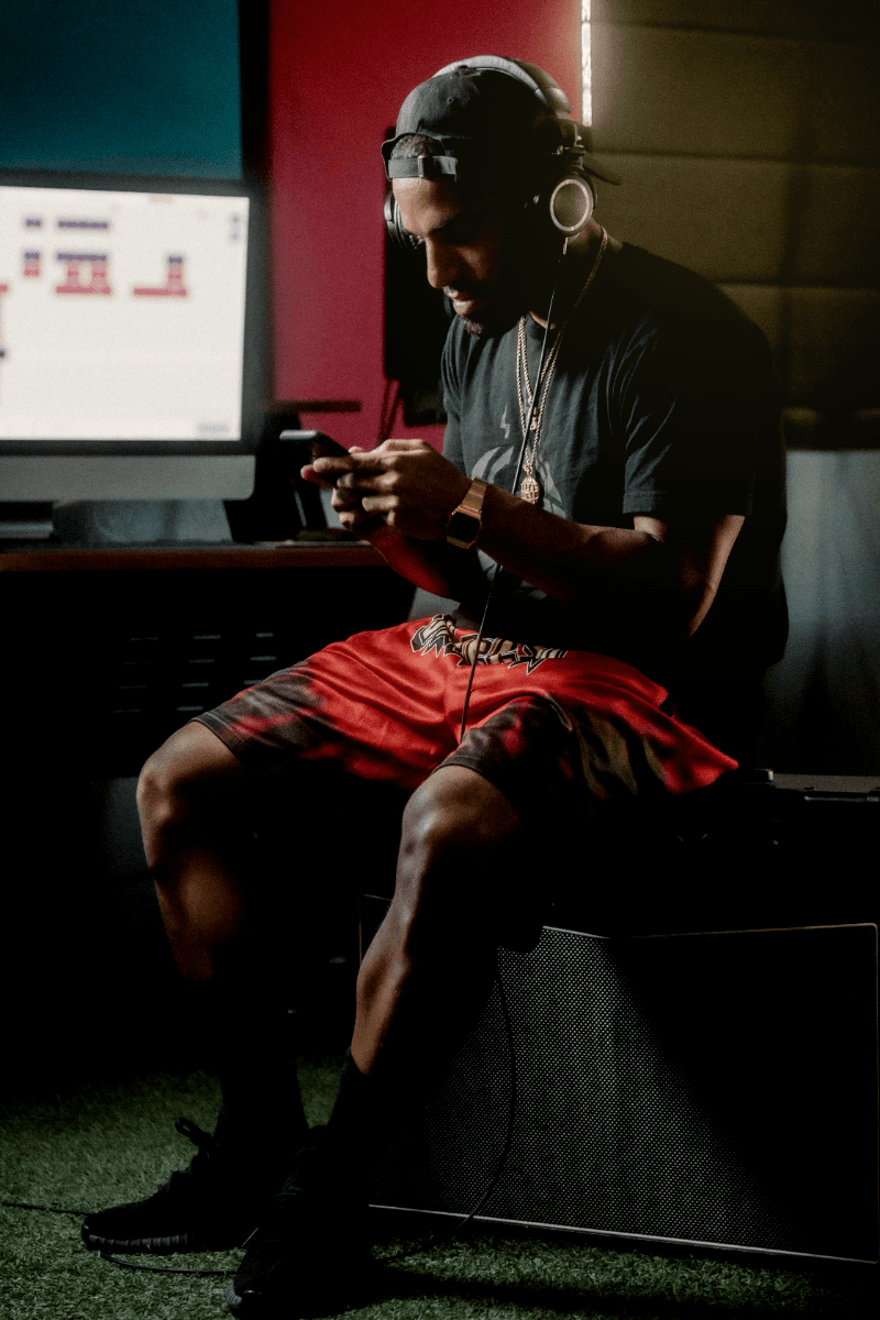 An athlete in headphones looking at his phone in a training facility.